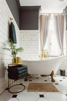 a bathroom with a white tub and a window at Glamour Old Town Blich Kraków in Kraków