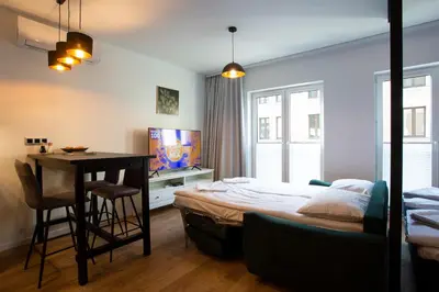 a bedroom with a bed and a table and a desk at Krakow Centrum Sunny Apartment Lwowska 10 in Kraków