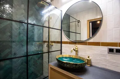 a bathroom with a sink and a glass shower at Krakow Centrum Sunny Apartment Lwowska 10 in Kraków