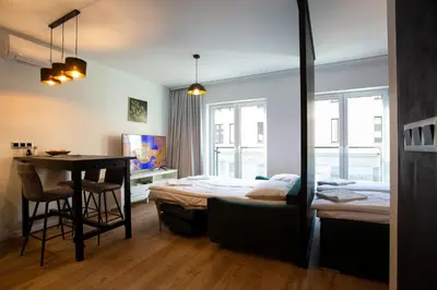 a bedroom with a bed and a table and a desk at Krakow Centrum Sunny Apartment Lwowska 10 in Kraków