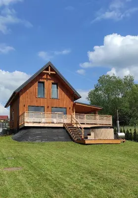 a large wooden house with a large yard at Sielski Zakątek Dąbrówka Domki in Dąbrówka