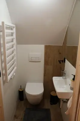 a bathroom with a toilet and a sink at Sielski Zakątek Dąbrówka Domki in Dąbrówka