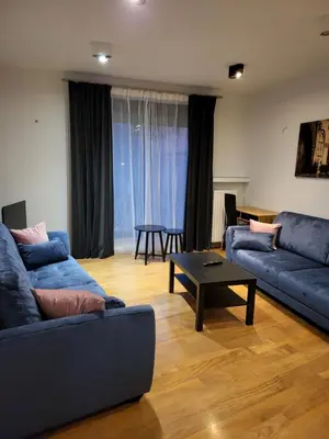 a living room with two blue couches and a table at AMBER APARTAMENt 127 in Kraków