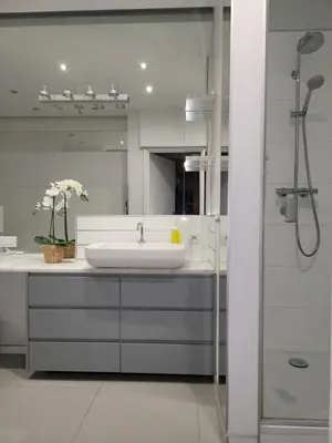 a white bathroom with a sink and a shower at AMBER APARTAMENt 127 in Kraków