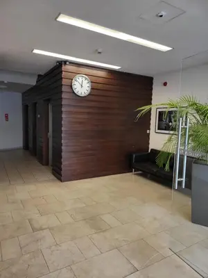 a clock on a wooden wall in a room at AMBER APARTAMENt 127 in Kraków