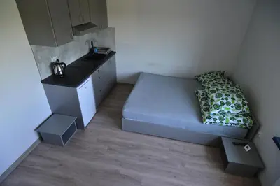 a small bedroom with a bed and a sink at Noclegi URAN in Sufczyn