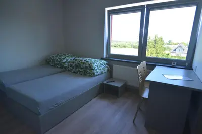 a small room with a couch and a desk and window at Noclegi URAN in Sufczyn