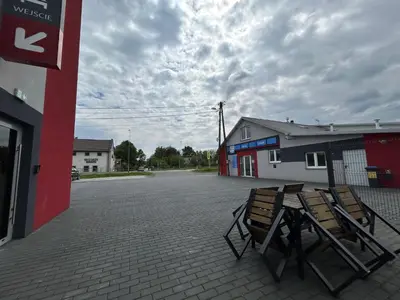 two chairs are sitting outside of a gas station at Noclegi URAN in Sufczyn