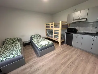 a small room with two beds and a kitchen at Noclegi URAN in Sufczyn