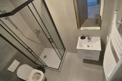 a bathroom with a shower and a sink and a toilet at Noclegi URAN in Sufczyn
