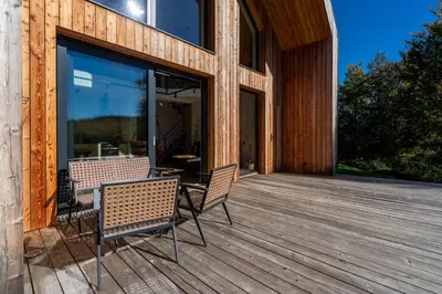 a deck with two chairs and a table on it at Drwalówka - Domek 
