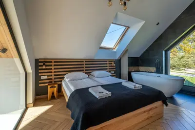 a bedroom with a bed and a bath tub at Drwalówka - Domek 