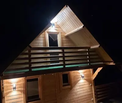 a view of a cabin with a staircase at night at Domek pod Hajdówką in Jordanów