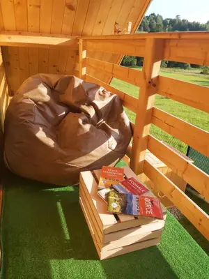 a dog house with a bed and some books at Domek pod Hajdówką in Jordanów