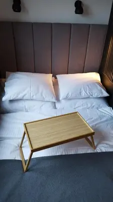 a bed with a wooden coffee table on it at Apartment Between in Kraków