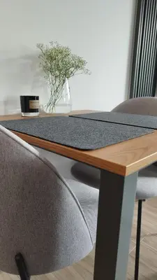 a wooden table with two chairs and a plant on it at Apartment Between in Kraków