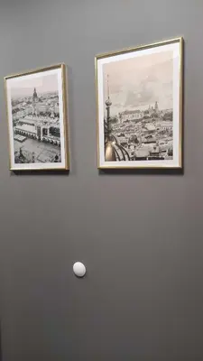 two pictures hanging on a wall with a ball on it at Apartment Between in Kraków