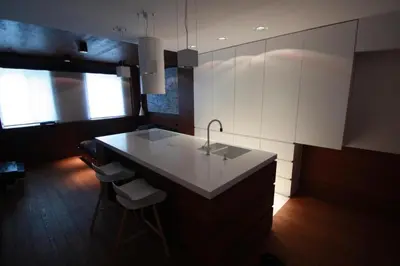 a kitchen with a sink and a counter with stools at Modern & Resto Apartments in Kraków