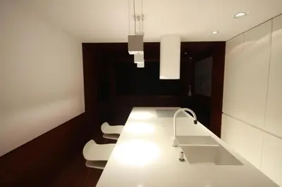a kitchen with a white counter and two white chairs at Modern & Resto Apartments in Kraków