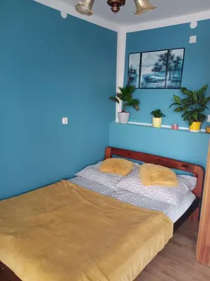 a blue bedroom with a bed with two pillows at POD RÓŻĄ in Kasina Wielka