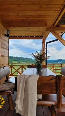 a wooden cabin with a table with a vase on it at Hamajdówka in Zubrzyca Górna