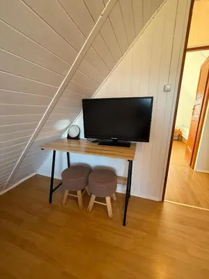 a desk with a television and two stools at Spacerowy Zakątek in Ślemień