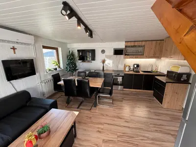a kitchen and living room with a couch and a table at Spacerowy Zakątek in Ślemień