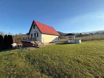 a white barn with a red roof in a field at Spacerowy Zakątek in Ślemień