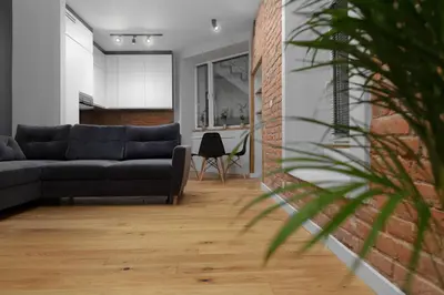 a living room with a couch and a brick wall at RELAX APARTMENT (Netflix, PS4, fotel masujący) in Kraków
