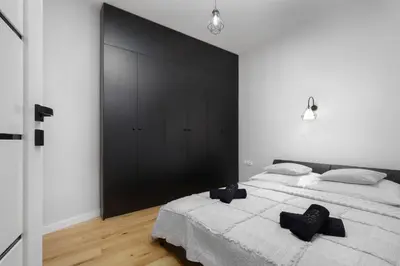 a bedroom with a large bed and a black wall at RELAX APARTMENT (Netflix, PS4, fotel masujący) in Kraków