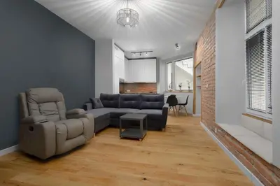 a living room with a couch and a chair at RELAX APARTMENT (Netflix, PS4, fotel masujący) in Kraków