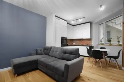 a living room with a gray couch and a table at RELAX APARTMENT (Netflix, PS4, fotel masujący) in Kraków