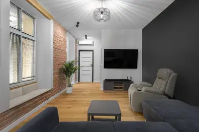 a living room with a couch and a flat screen tv at RELAX APARTMENT (Netflix, PS4, fotel masujący) in Kraków