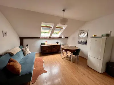 a living room with a blue couch and a table at Appartement Vieille Ville in Kraków