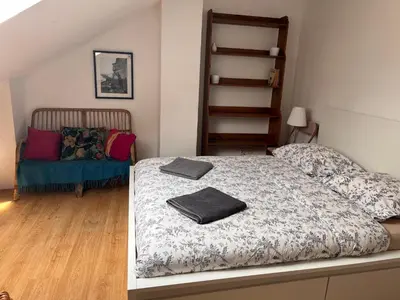 a small bedroom with a bed and a chair at Appartement Vieille Ville in Kraków