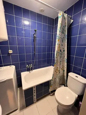 a blue tiled bathroom with a toilet and a sink at Appartement Vieille Ville in Kraków