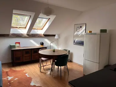 a kitchen with a table and a refrigerator at Appartement Vieille Ville in Kraków