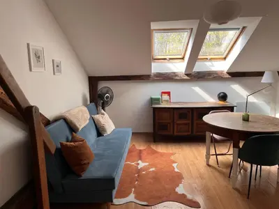 a living room with a blue couch and a table at Appartement Vieille Ville in Kraków