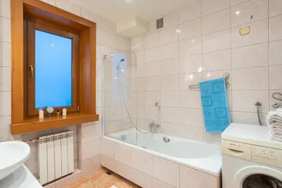a bathroom with a tub and a sink and a washing machine at Apartamenty w Gorcach in Nowy Targ