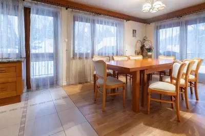 a dining room with a wooden table and chairs at Apartamenty w Gorcach in Nowy Targ