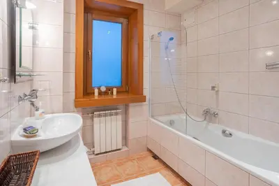 a bathroom with a bath tub and a sink and a bath tub at Apartamenty w Gorcach in Nowy Targ