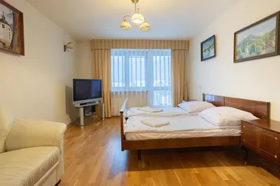 a bedroom with a bed and a couch and a television at Apartamenty w Gorcach in Nowy Targ