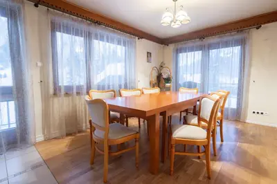 a dining room with a wooden table and chairs at Apartamenty w Gorcach in Nowy Targ