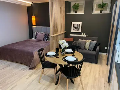 a bedroom with a bed and a table and a couch at Petit Appartement in Kraków