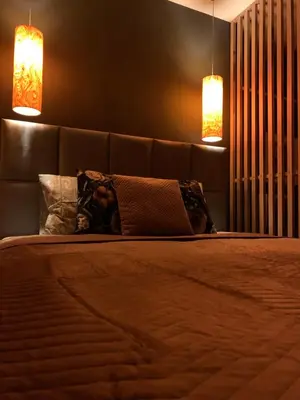 a bedroom with a bed with two lights on it at Petit Appartement in Kraków