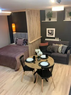 a bedroom with a bed and a table and a couch at Petit Appartement in Kraków