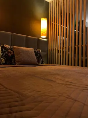 a bedroom with a bed with a headboard and a lamp at Petit Appartement in Kraków