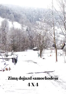 a snow covered field with trees and a mountain at Sielsko Anielsko in Stryszawa