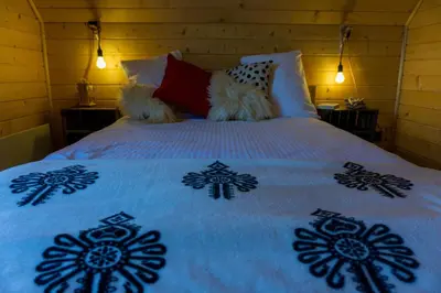 a bed with a white bedspread with flowers on it at Sielsko Anielsko in Stryszawa