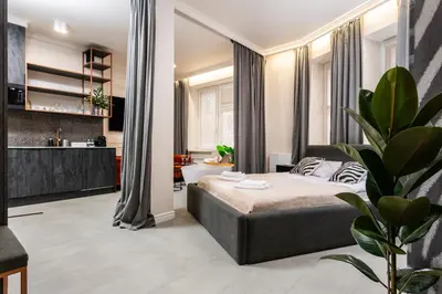 a bedroom with a bed and a living room at Apartamenty Jubilat - KRK FOR STAY in Kraków